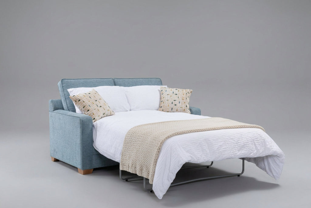 Alstons Olly sofa bed in pale blue fabric, opened into a bed with white bedding