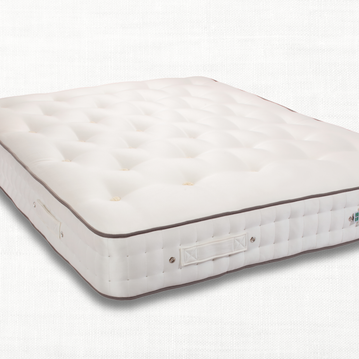 Enchanted House Lustleigh  white tufted mattress shown at an angle against a light grey textured background