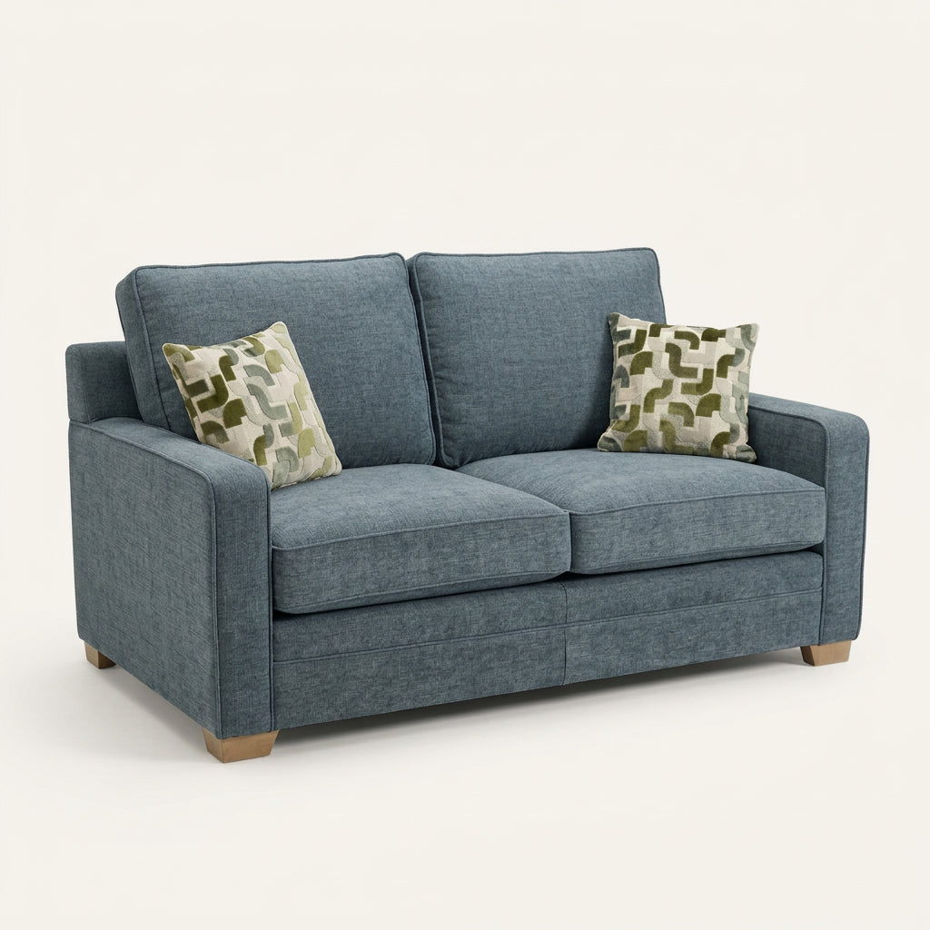 Alstons Olly sofa bed in blue fabric with patterned scatter cushions and light wooden feet