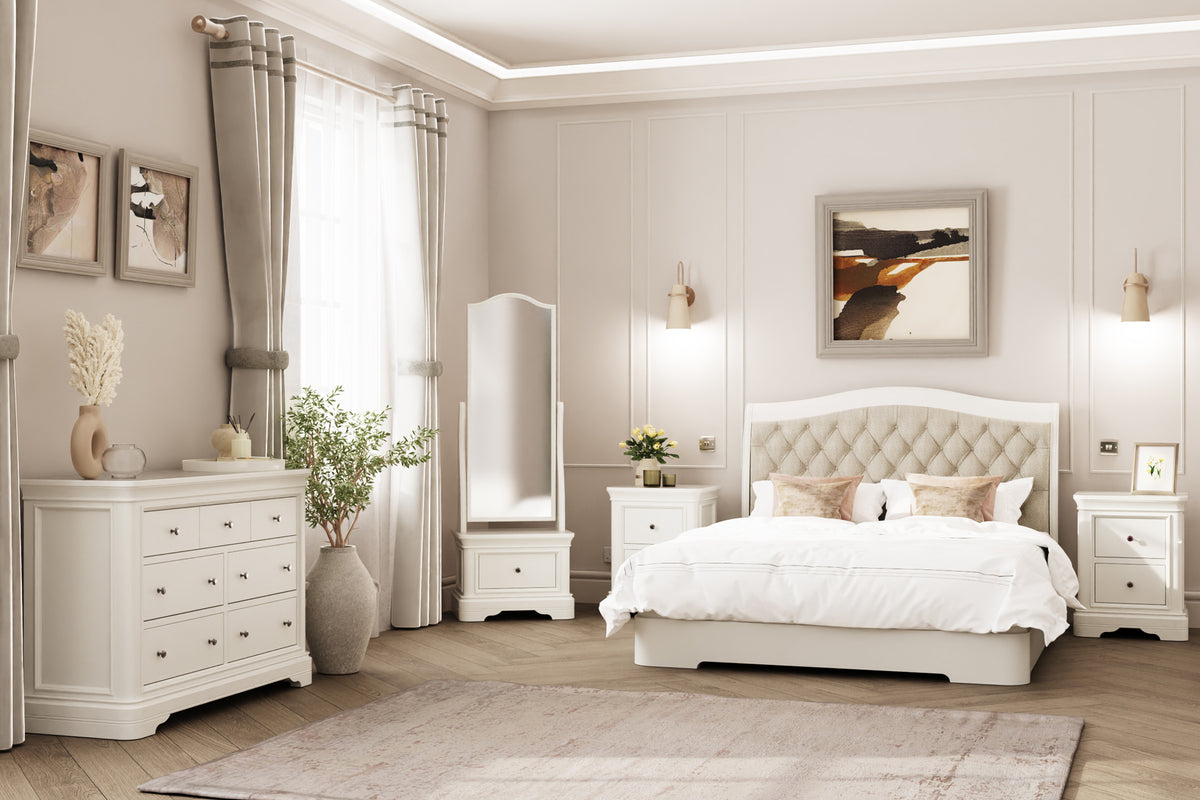 Cream upholstered bed with a buttoned headboard and matching white bedroom furniture

